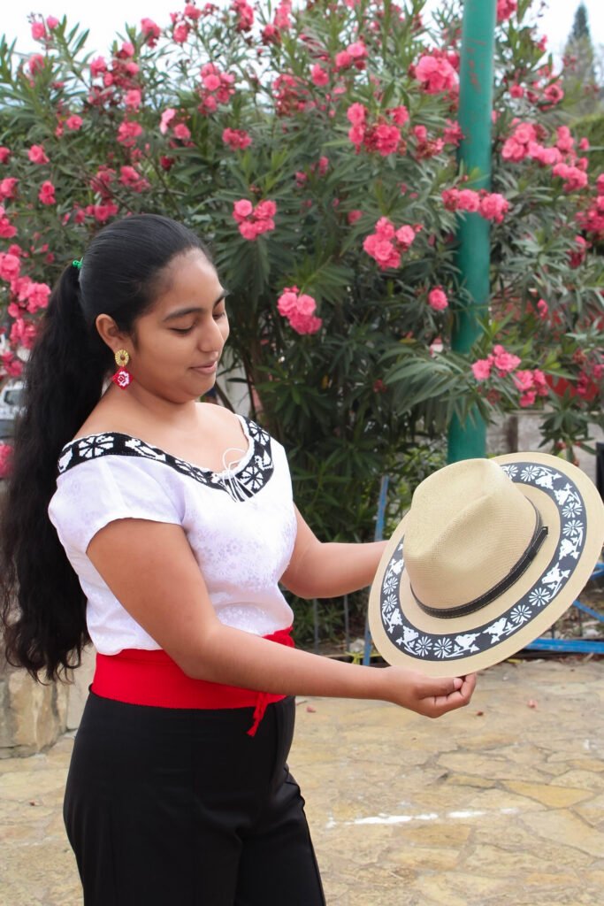 mujer zoque sosteniendo un sombrero pintado a mano alusivo al borado zoque de copainala