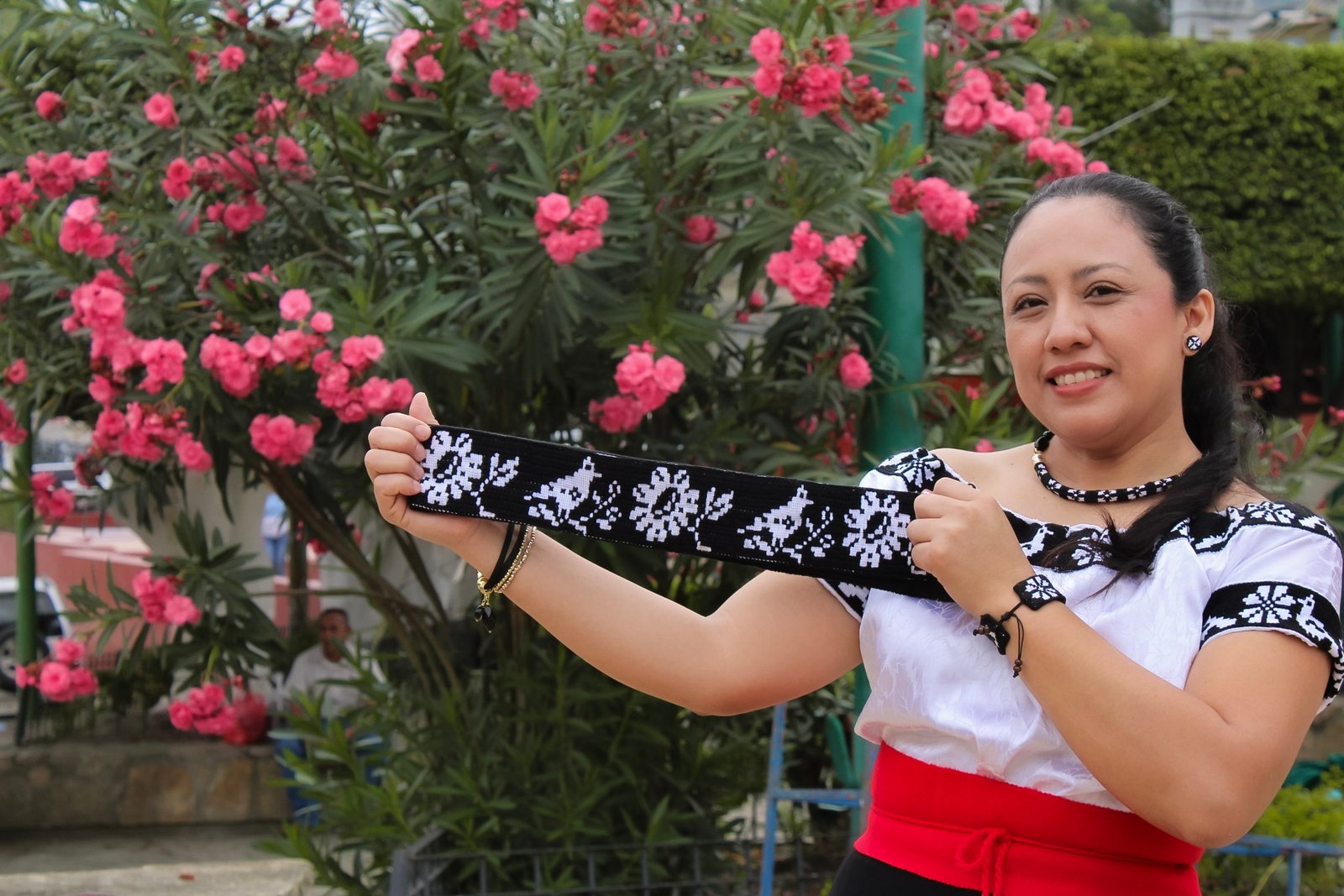 mujer emprendedora Zoque de sunyipa yomo enseñando su producto tira con bordado zoque