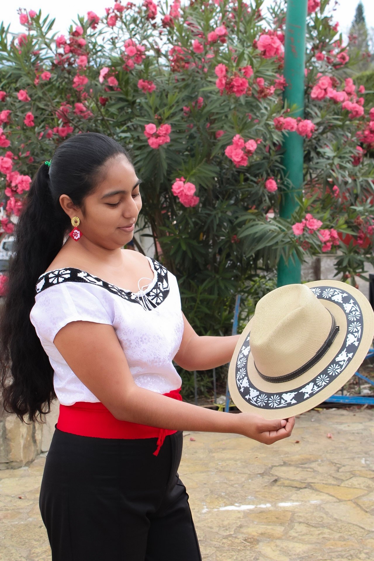 mujer zoque emprendedora mostrando un sombrero pintado a mano