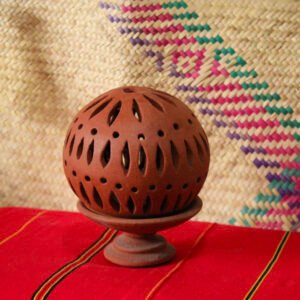Portavelas artesanal de barro con diseño calado. Ideal para iluminar espacios con velas y crear un ambiente cálido y decorativo.